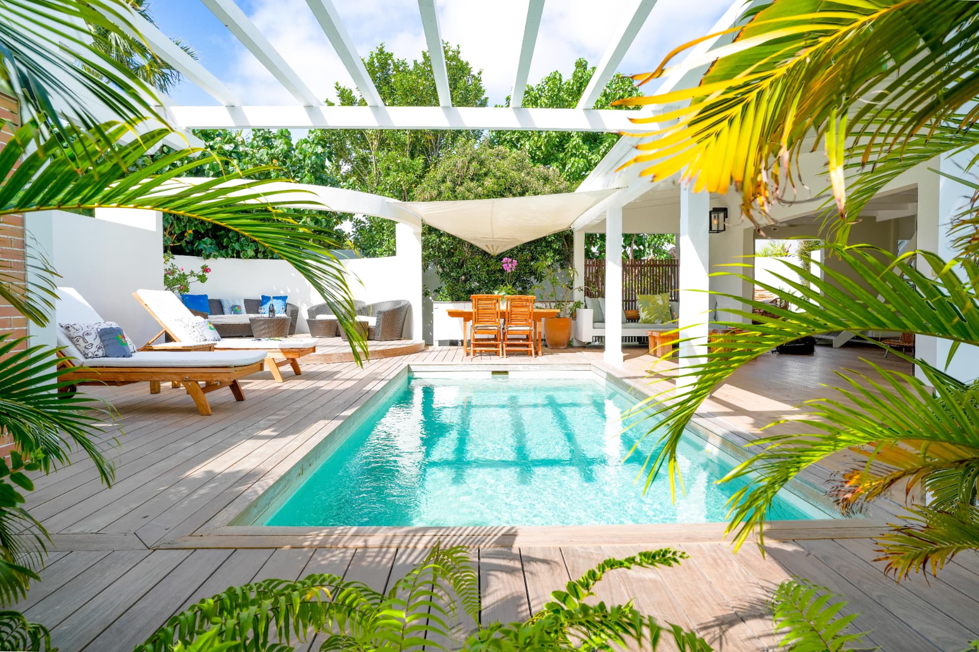 Patio et piscine privée, deck bois, brise-soleil et végétation tropicale